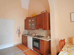 kuchnia z drewnianymi szafkami i kuchenką z piekarnikiem w obiekcie Apartment Carovigno by Interhome w mieście Carovigno