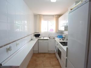 cocina blanca con fregadero y nevera en Holiday Home Zona Estival-2 by Interhome, en Salou