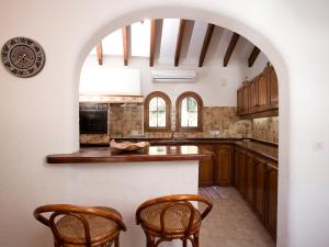 una cocina con encimera y 2 sillas. en Holiday Home Luz y Paz by Interhome, en Altea la Vieja