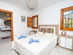 a bedroom with a large bed with blue pillows on it at Holiday Home Amadorio by Interhome in Benitachell