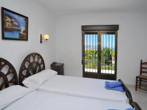 ein Schlafzimmer mit einem weißen Bett und einem Fenster in der Unterkunft Holiday Home Tosalans by Interhome in Balcon del Mar