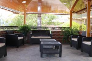 un patio con sillas, mesas y chimenea en Hosteria Quinta San Miguel, en Ibarra