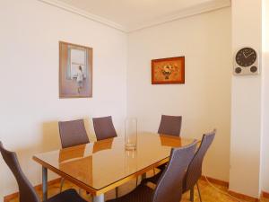 mesa de comedor con sillas y reloj en la pared en Apartment Altea Dorada by Interhome, en Altea la Vieja