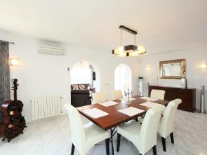 a dining room with a wooden table and white chairs at Holiday Home Tubingen by Interhome in Fanadix