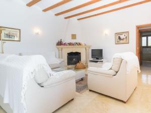 ein weißes Zimmer mit 2 Stühlen und einem Kamin in der Unterkunft Holiday Home Tesoro Park by Interhome in Benitatxell