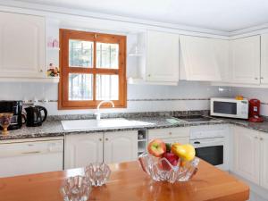 una cocina con armarios blancos y un bol de fruta en una mesa en Holiday Home Cabanyes by Interhome en Calonge