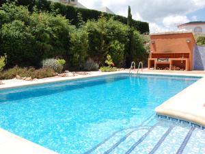 a swimming pool with blue water in a yard at Villa Corona by Interhome in Beniarbeig