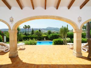 eine Terrasse mit einem Torbogen und einem Pool in der Unterkunft Holiday Home Tesoro Park by Interhome in Benitatxell
