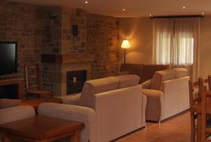 a living room with a couch and chairs and a fireplace at Casa Rural Espargoiti in Salinas de Ibargoiti