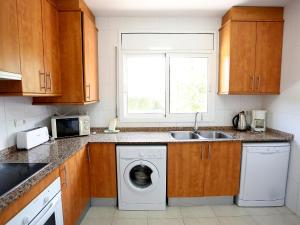 una cucina con lavatrice e lavandino di Villa Villa Llobeta by Interhome a Les tres Cales