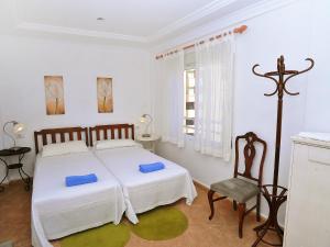 ハベアにあるApartment Monada by Interhomeの白いベッドルーム(ベッド1台、椅子付)