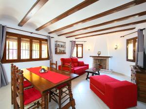 ein Wohnzimmer mit einem Tisch und roten Stühlen in der Unterkunft Villa Les Canyes by Interhome in Denia