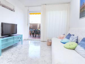 a living room with a white couch and a tv at Apartment Fleming by Interhome in Lloret de Mar