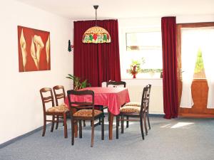 a dining room with a red table and chairs at Apartment Kopei by Interhome in Eschenbruch