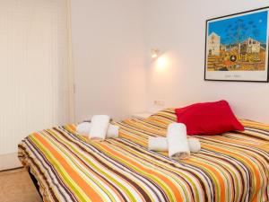 1 dormitorio con 1 cama con toallas en Apartment Primer de Maig by Interhome, en Sitges