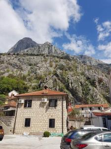 a building with a mountain in the background at Viktor Rooms in Kotor