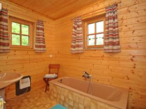 baño con bañera y lavamanos en una cabaña de madera en Chalet Haus Ahlfeld by Interhome en Sankt Aegyd am Neuwalde