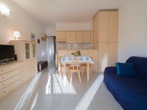 - un salon avec une table et un canapé bleu dans l'établissement Apartment Casina by Interhome, à Porto Azzurro