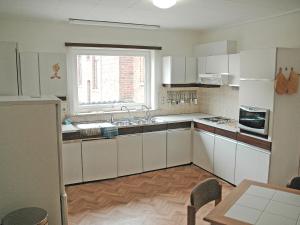 uma grande cozinha com armários brancos e uma janela em Apartment Poperinge by Interhome em Poperinge