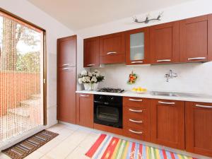 cocina con armarios de madera, fregadero y ventana en Apartment Il Cipresso by Interhome, en San Baronto