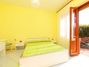 a bedroom with a bed in a yellow room at Apartment Il Cipresso by Interhome in San Baronto