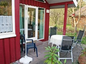 eine Terrasse mit einem Tisch und Stühlen auf einem roten Haus in der Unterkunft Holiday Home Ferienpark Extertal by Interhome in Rott