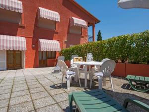 a patio with a table and chairs and a building at Apartment Il Cipresso by Interhome in San Baronto