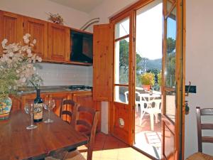 a kitchen and dining room with a table and a balcony at Apartment Villa Morosi-1 by Interhome in San Baronto
