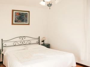 フォルテ・デイ・マルミにあるVilla Dea by Interhomeの白いベッドと壁の絵が備わるベッドルーム1室が備わります。