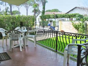 un patio con mesa, sillas y una valla en Villa Dea by Interhome, en Forte dei Marmi