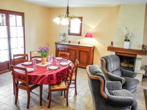 comedor con mesa, sillas y chimenea en Holiday Home Les Chenes by Interhome en Salviac