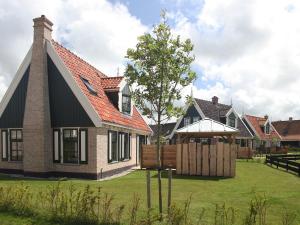 una casa con una valla en el patio en Holiday Home Wiringherlant-5 by Interhome, en Noordstroe