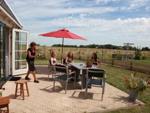 NoordstroeにあるHoliday Home Wiringherlant-2 by Interhomeの傘下のテーブルに座る女性の集団