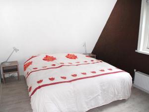 NoordstroeにあるHoliday Home Wiringherlant-6 by Interhomeのベッドルーム1室(赤い花の白いベッド1台付)