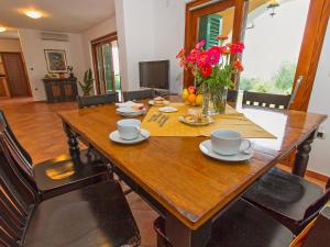 a wooden dining table with chairs and flowers on it at Villa Marina by Interhome in Diminići +21 photos