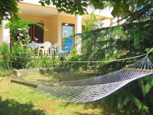 a hammock in a yard in front of a house at Apartment Neda by Interhome in VeliGolji