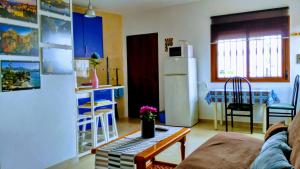 a living room with a couch and a kitchen with a refrigerator at Apartamento el Parador in Carratraca