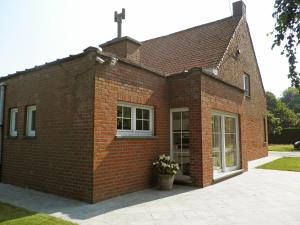 un bâtiment en briques avec une croix au-dessus dans l'établissement Holiday Home Hulstehof by Interhome, à Ruyterhoek