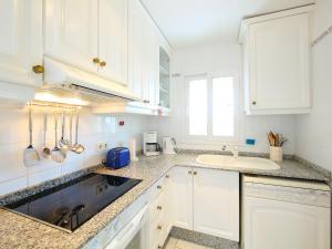 a kitchen with white cabinets and a sink at Holiday Home B&B by Interhome in Calpe