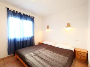 a bedroom with a bed and a window with blue curtains at Holiday Home Pla del Mar by Interhome in Moraira