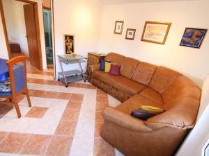 a living room with a brown leather couch and a table at Holiday Home Ratimir by Interhome in Rogač