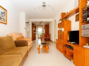 uma sala de estar com um sofá e uma televisão em Apartment Cascadas de la Marina-4 by Interhome em Denia