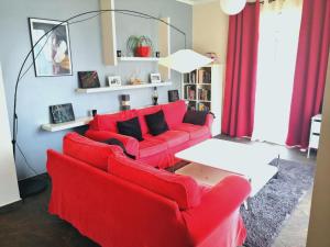 a living room with red couches and a white table at Casa do Vale in São Vicente