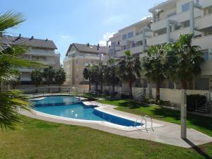 a swimming pool in front of a large apartment building at Apartment Elegance-2 by Interhome in Denia