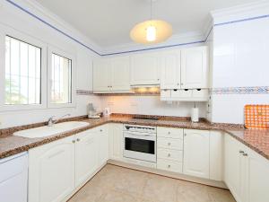 a white kitchen with white cabinets and a sink at Holiday Home Tossal Gros by Interhome in Denia