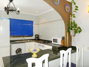 a kitchen with a table and two white chairs at Holiday Home Etxe Zuri by Interhome in Calpe