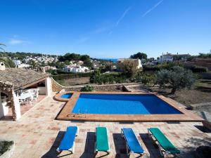 een zwembad met ligstoelen en een villa bij Holiday Home Els Pins by Interhome in Benissa