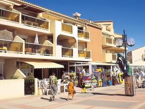 a group of people walking in front of a building at Lagrange Vacances Les Résidences in Sainte-Marie-Plage