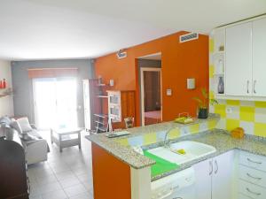 cocina con fregadero y pared de color naranja en Apartment Las Dunas-3 by Interhome, en Denia