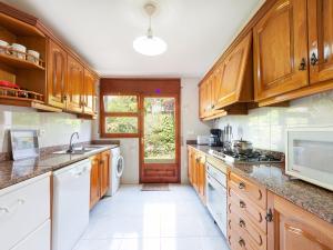 a kitchen with wooden cabinets and white appliances at Holiday Home Mas Vila by Interhome in Sant Antoni de Calonge